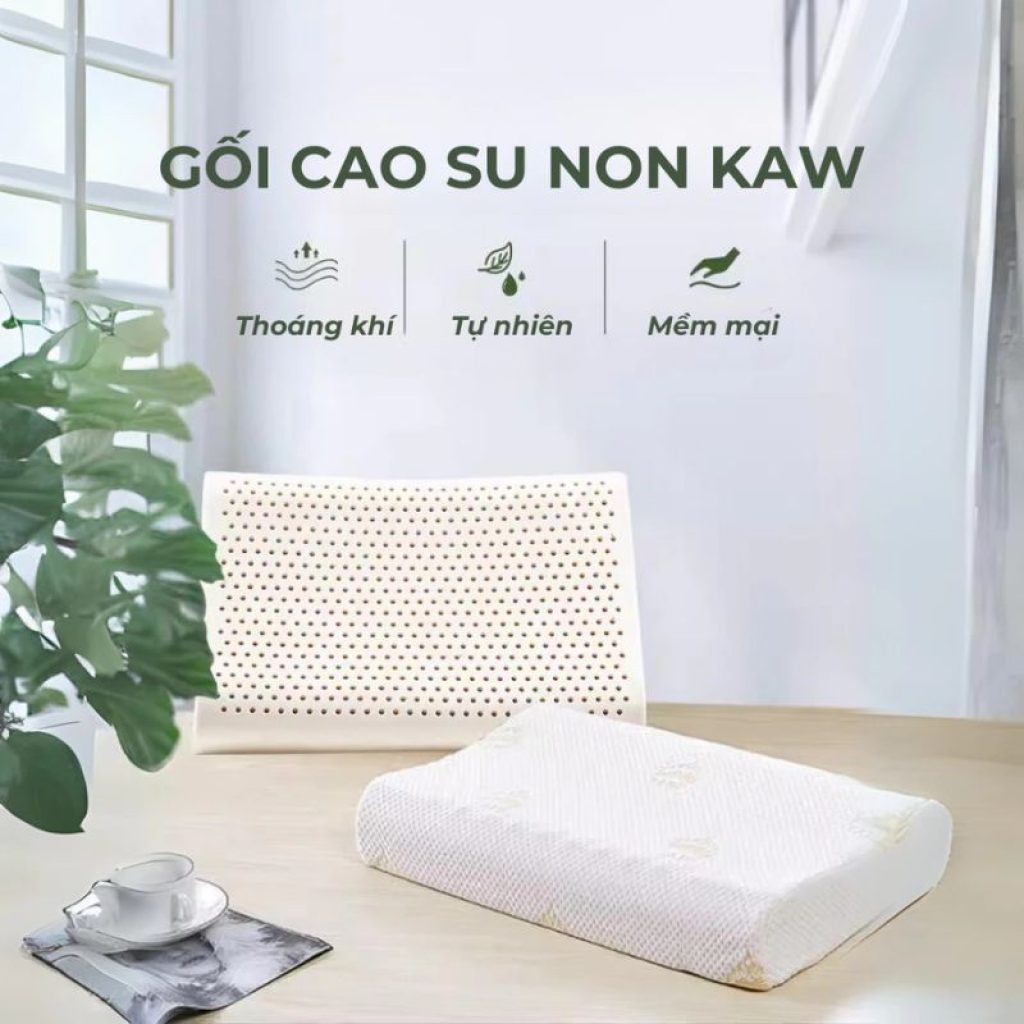 Gối cao su non KAW màu trắng, bề mặt có hàng ngàn lỗ thoáng khí, đặt trên bàn gỗ cạnh cây xanh, thể hiện tính tự nhiên và mềm mại.